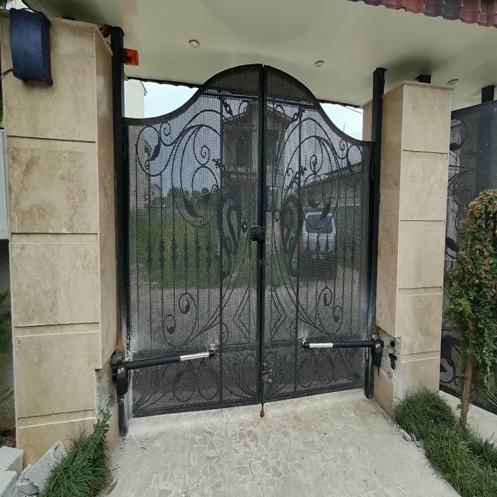 جک پارکینگی نقره‌ای در کنار ستون آجری ساختمان ویلایی