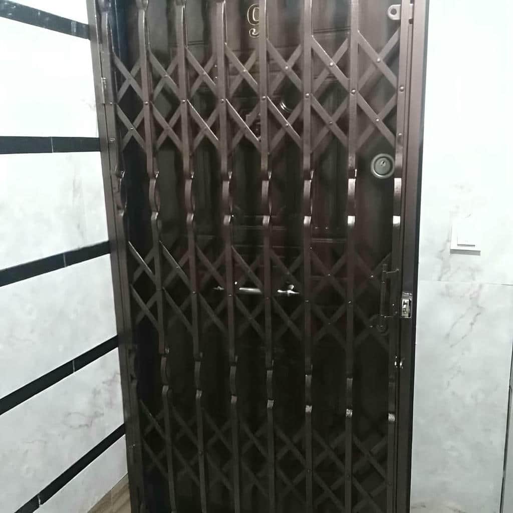 حفاظ درب آکاردئونی خاکستری در راهروی بازسازی‌شده رشت