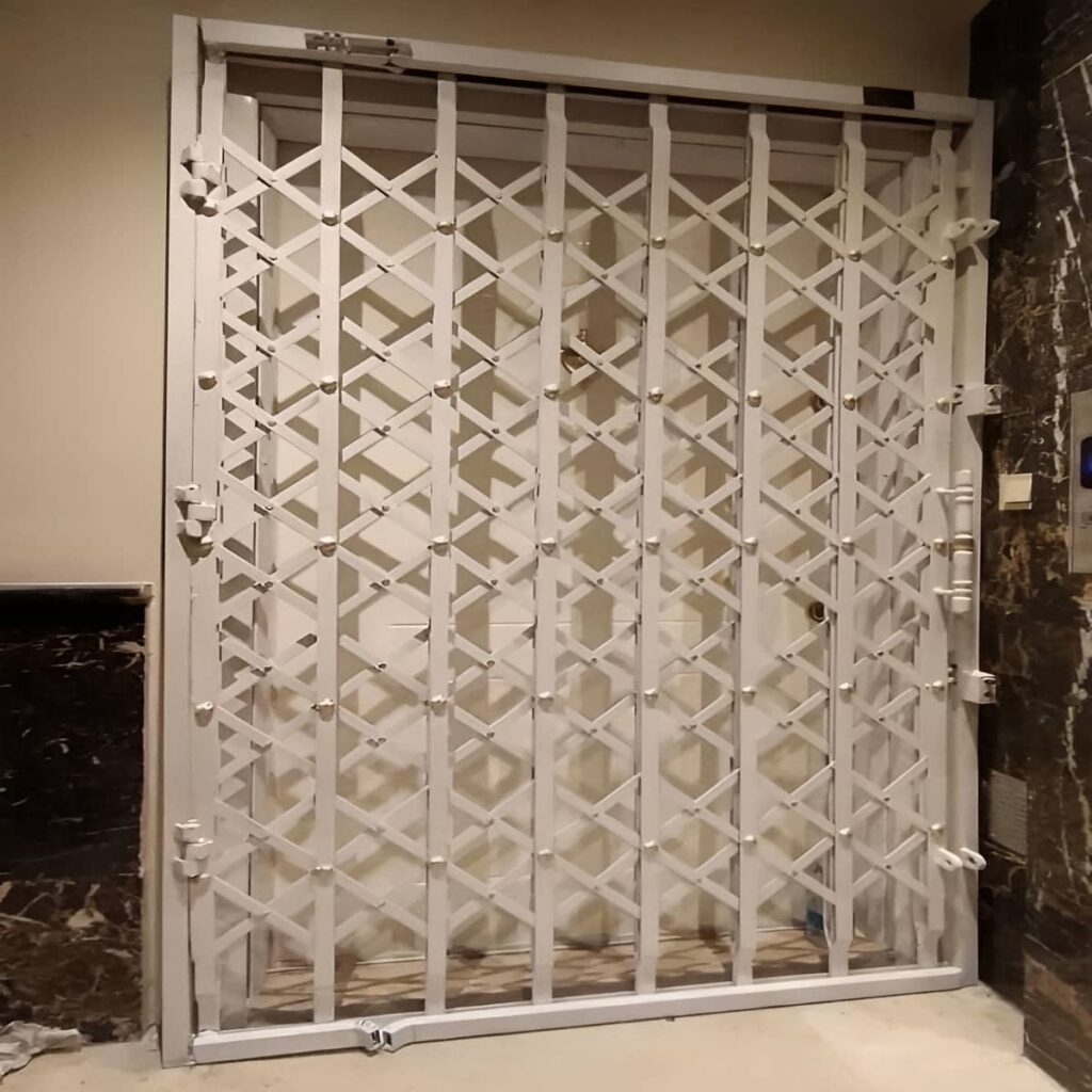 حفاظ درب آکاردئونی سفید کنار پنجره پاگرد