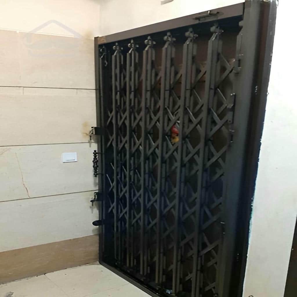 حفاظ درب آکاردئونی مشکی مقابل اتاق مهمان استان کرمان