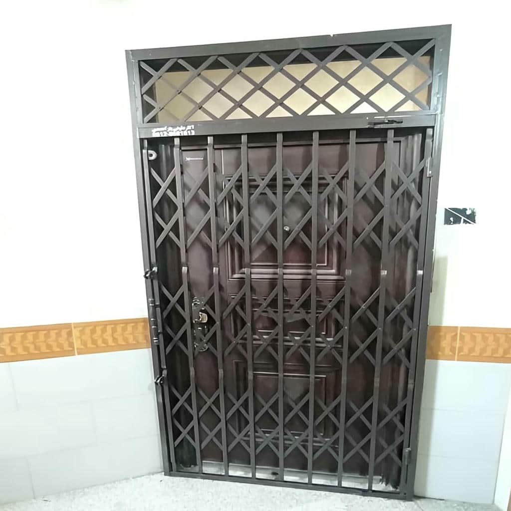 حفاظ درب آکاردئونی مشکی نصب شده بر چهارچوب استان کردستان