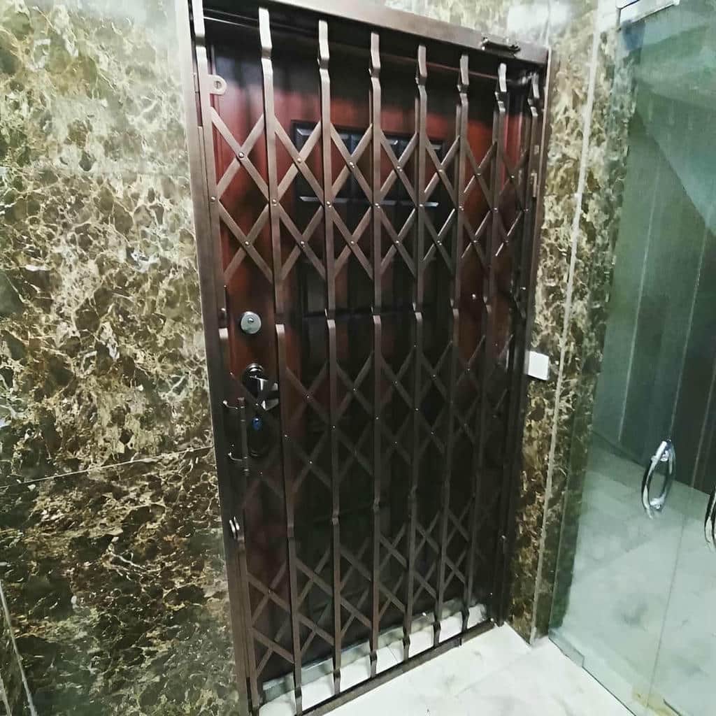 محافظ آکاردئونی سفید نصب شده کنار چهارچوب آپارتمان محافظ آکاردئونی سفید نصب شده کنار چهارچوب آپارتمان