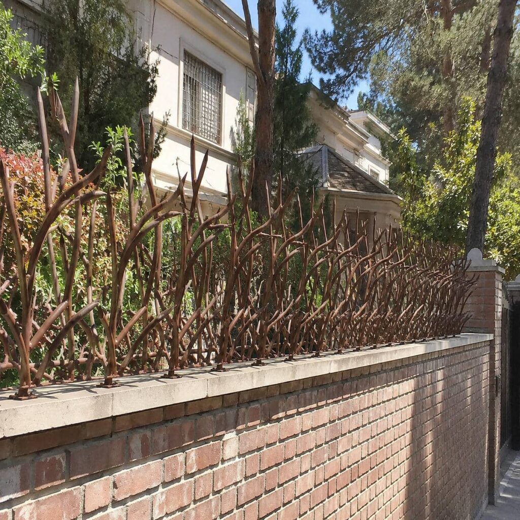 نرده سرنیزه ای زغالی کنار دروازه آهنی سنتی