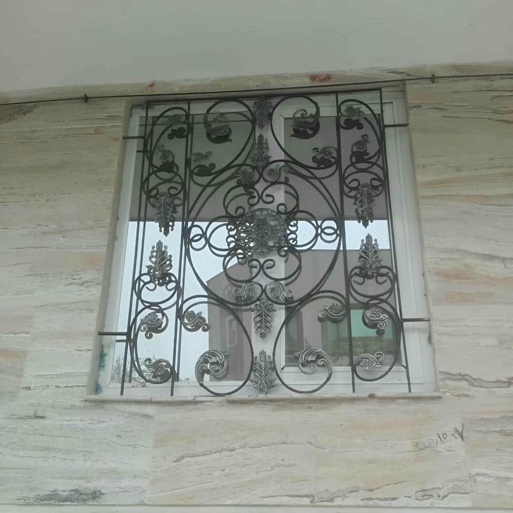 نرده پنجره مشکی در نمای سنگی خانه