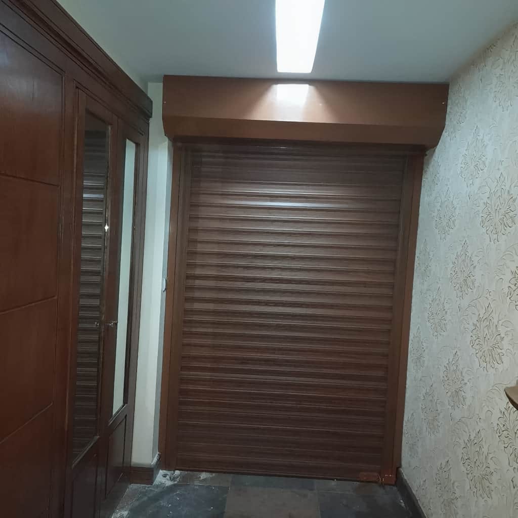 کرکره برقی مشکی مقابل نمای سنگی ساختمان