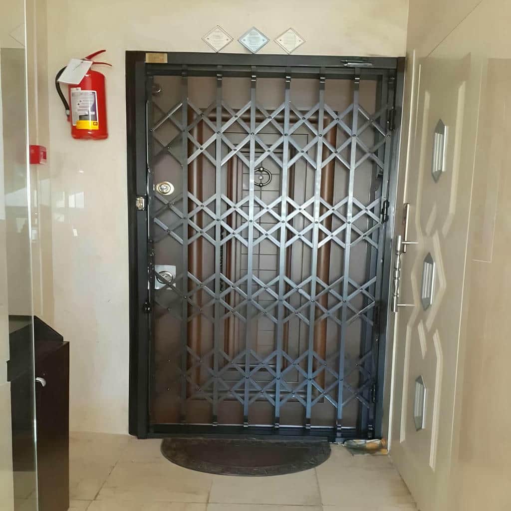 گارد فلزی مشکی کنار درب سفید ساختمان نوساز